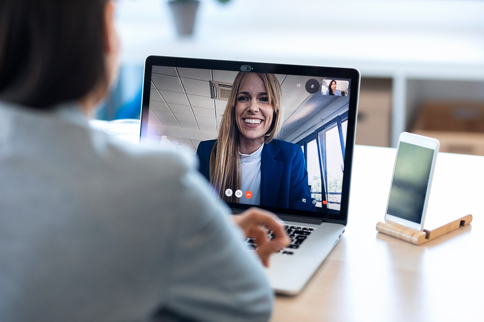 Female employee speaking on video call with her colleague on onl